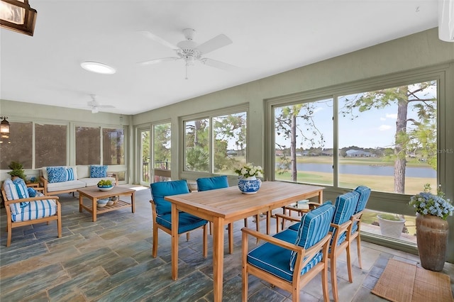 sunroom / solarium featuring an outdoor living space, a ceiling fan, and a water view