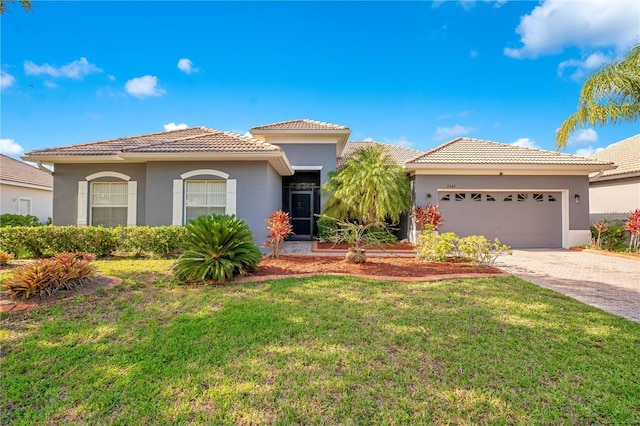 2641 Meadow View Ct, Kissimmee, FL 34746 - mediterranean / spanish home with a garage, a tile roof, stucco siding, driveway, and a front yard