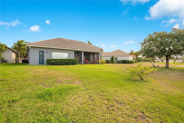 2641 Meadow View Ct, Kissimmee, FL 34746 - rear view of property featuring a yard, stucco siding, and a sunroom