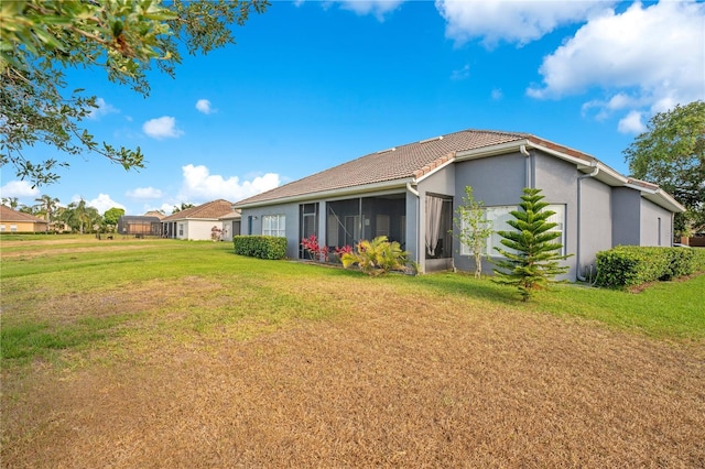 2641 Meadow View Ct, Kissimmee, FL 34746 - back of house featuring a yard, stucco siding, and a sunroom