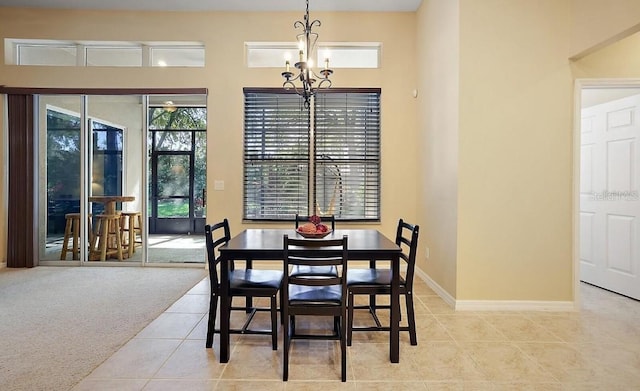tiled dining room featuring baseboards and an inviting chandelier