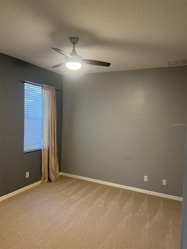 unfurnished room with carpet flooring, a textured ceiling, ceiling fan, and visible vents