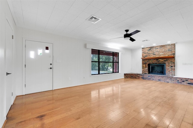 274 W Kings Hwy, Center Hill, FL 33514 - unfurnished living room with ceiling fan, visible vents, a fireplace, ornamental molding, and light wood-style flooring