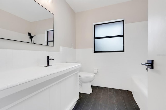 274 W Kings Hwy, Center Hill, FL 33514 - bathroom with vanity, toilet, a wainscoted wall, tile walls, and wood finished floors