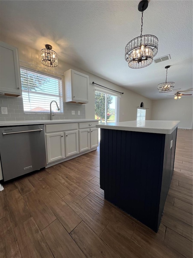 kitchen featuring tasteful backsplash, a chandelier, light countertops, dark wood-style floors, and dishwasher