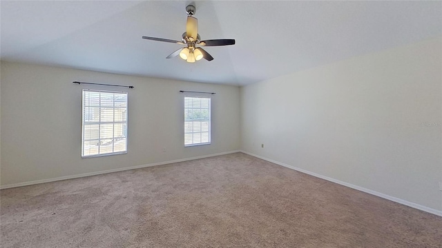 carpeted empty room featuring ceiling fan and baseboards