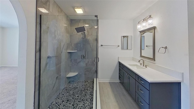 bathroom with vanity, a shower stall, and baseboards