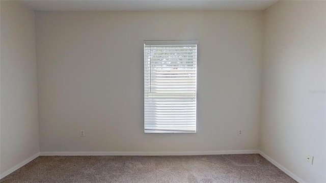 unfurnished room featuring baseboards and carpet flooring