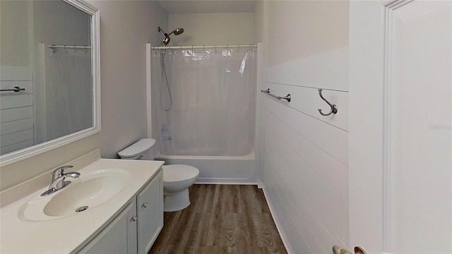 bathroom with shower / bath combo with shower curtain, wood finished floors, toilet, and vanity
