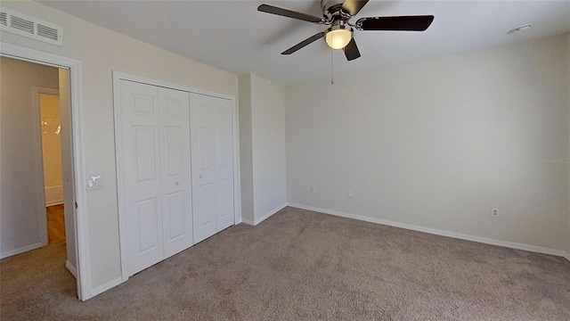 unfurnished bedroom with carpet flooring, a closet, visible vents, and baseboards