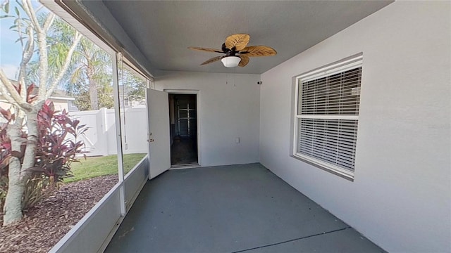 unfurnished sunroom with ceiling fan