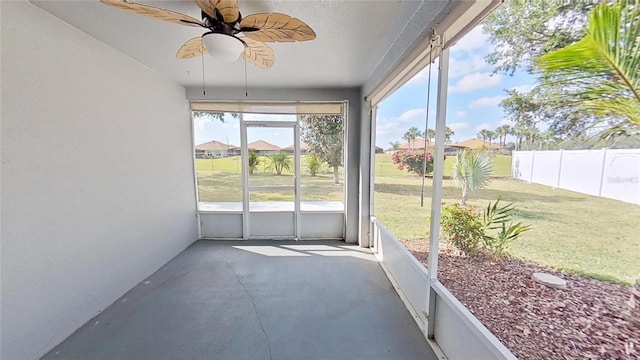 unfurnished sunroom with ceiling fan