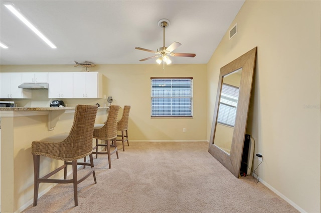 interior space featuring a ceiling fan, baseboards, visible vents, and light carpet
