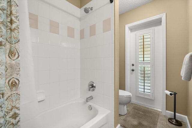 bathroom with baseboards, toilet, and shower / tub combo with curtain