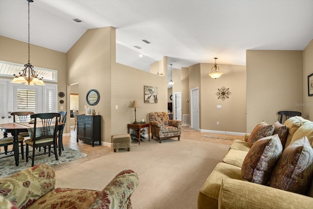 living area featuring high vaulted ceiling, baseboards, light carpet, and visible vents