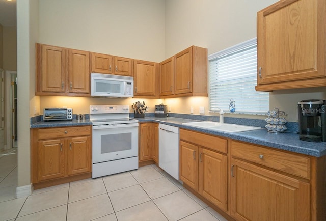 2539 Caithness Way, Clermont, FL 34714 - kitchen with white appliances, a high ceiling, dark countertops, a sink, and light tile patterned flooring