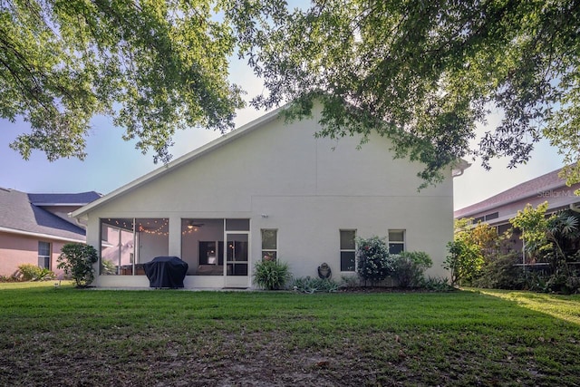 2539 Caithness Way, Clermont, FL 34714 - back of property featuring a sunroom, a lawn, and stucco siding