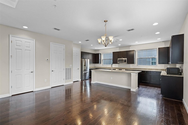 kitchen featuring appliances with stainless steel finishes, an inviting chandelier, light countertops, dark wood finished floors, and visible vents
