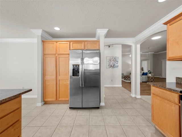 951 Chapman Loop, The Villages, FL 32162 - kitchen featuring stainless steel fridge with ice dispenser, ornamental molding, light tile patterned floors, baseboards, and dark stone countertops