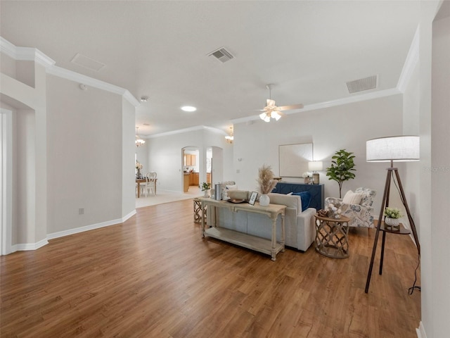 951 Chapman Loop, The Villages, FL 32162 - living room with ornamental molding, arched walkways, wood finished floors, baseboards, and ceiling fan
