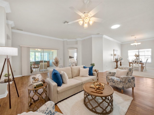 951 Chapman Loop, The Villages, FL 32162 - living room with wood finished floors, baseboards, ornamental molding, a chandelier, and arched walkways