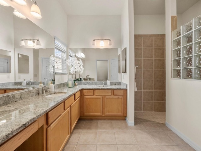 951 Chapman Loop, The Villages, FL 32162 - bathroom featuring tile patterned flooring, a walk in shower, double vanity, and baseboards