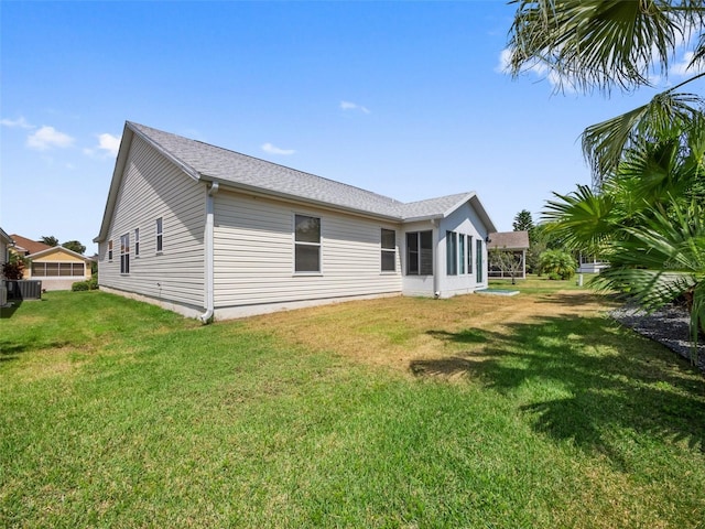 951 Chapman Loop, The Villages, FL 32162 - back of property featuring a yard, central AC unit, and roof with shingles