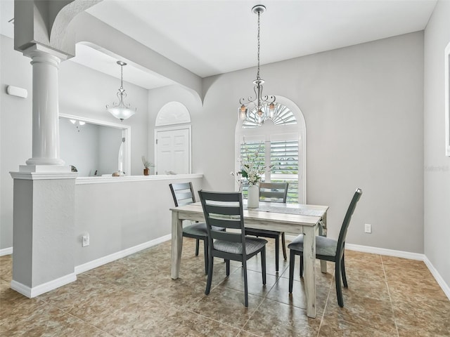 dining room featuring an inviting chandelier, baseboards, and ornate columns