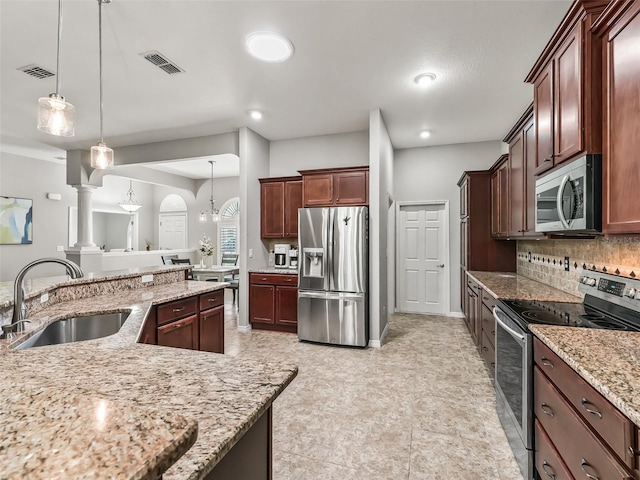 kitchen featuring backsplash, stainless steel appliances, visible vents, and a sink