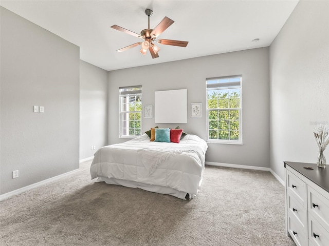 bedroom with ceiling fan, light carpet, and baseboards