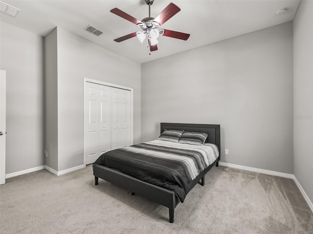 carpeted bedroom featuring baseboards, a closet, visible vents, and a ceiling fan