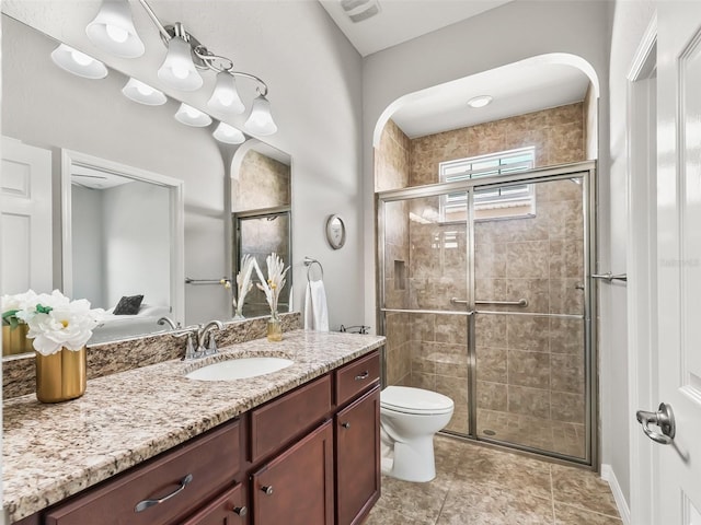 bathroom with a shower stall, toilet, vanity, and visible vents