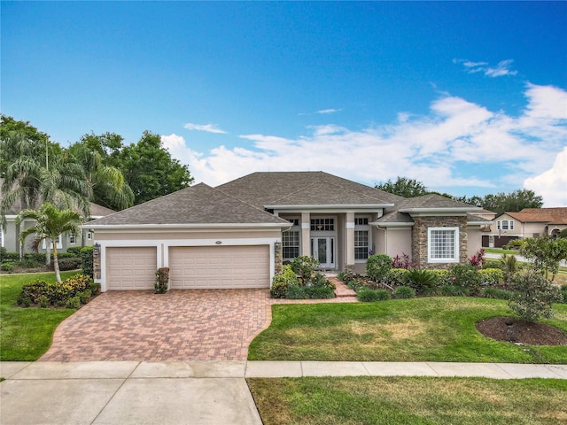 1473 Lakemist Ln, Clermont, FL 34711 - view of front of property featuring decorative driveway, a front lawn, an attached garage, stone siding, and stucco siding