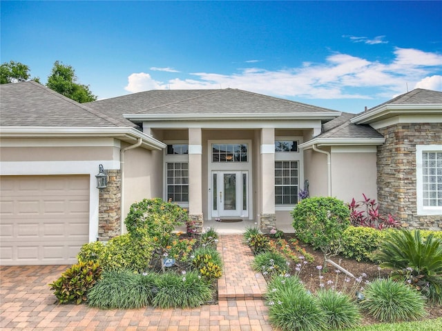 1473 Lakemist Ln, Clermont, FL 34711 - doorway to property with stone siding, roof with shingles, stucco siding, an attached garage, and driveway