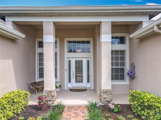 1473 Lakemist Ln, Clermont, FL 34711 - doorway to property featuring a porch, stone siding, and stucco siding