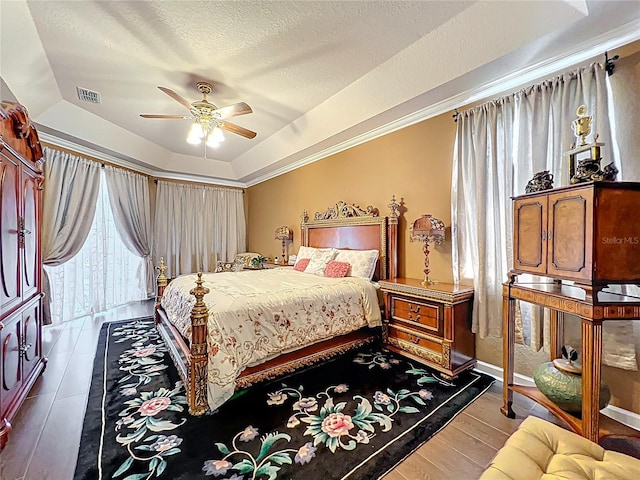 1473 Lakemist Ln, Clermont, FL 34711 - bedroom featuring visible vents, wood finished floors, ceiling fan, a textured ceiling, and a raised ceiling