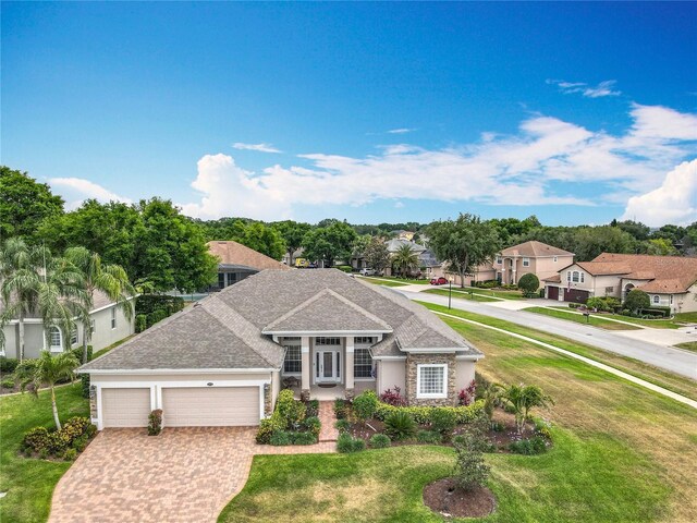 1473 Lakemist Ln, Clermont, FL 34711 - view of front of home featuring a garage, a front lawn, driveway, and a residential view