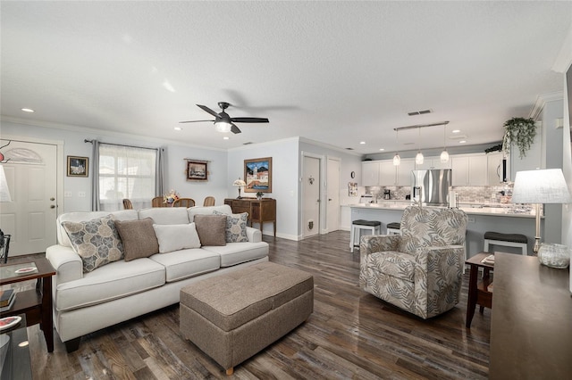 living area with ceiling fan, dark wood finished floors, crown molding, and visible vents