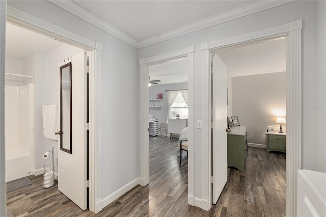 corridor featuring crown molding, baseboards, and wood finished floors