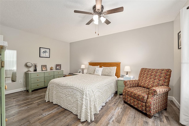 bedroom featuring ceiling fan, baseboards, and wood finished floors