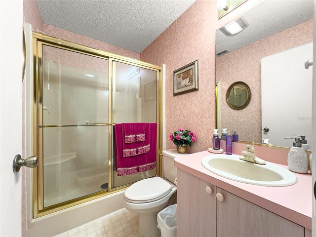 2102 Estevez Dr, Lady Lake, FL 32159 - bathroom featuring a textured ceiling, vanity, toilet, a shower stall, and tile patterned floors