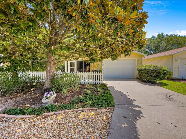 2102 Estevez Dr, Lady Lake, FL 32159 - view of property hidden behind natural elements with driveway and an attached garage