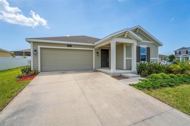 5354 Travertine St, Mount Dora, FL 32757 - view of front facade featuring board and batten siding, a front yard, a garage, fence, and concrete driveway
