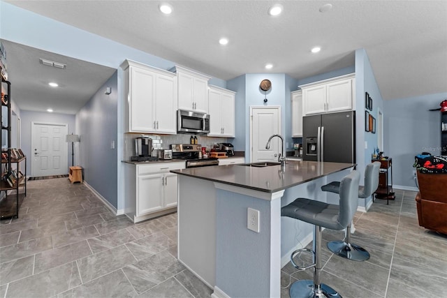 5354 Travertine St, Mount Dora, FL 32757 - kitchen featuring dark countertops, a breakfast bar, a sink, stainless steel appliances, and baseboards