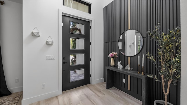 foyer entrance featuring baseboards and wood finished floors