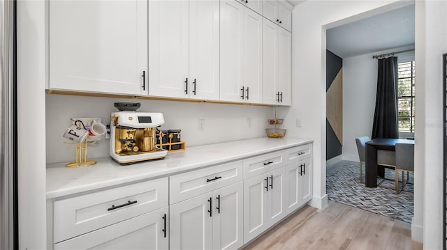 bar featuring light wood-style floors and baseboards