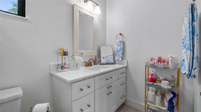 half bath featuring vanity and toilet