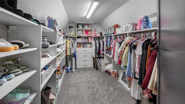 walk in closet featuring carpet floors and lofted ceiling