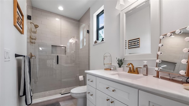 bathroom with toilet, a shower stall, and vanity