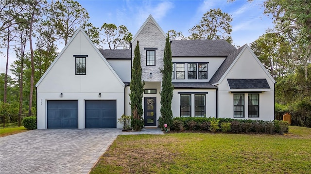 modern inspired farmhouse with decorative driveway, a front lawn, stucco siding, and a shingled roof